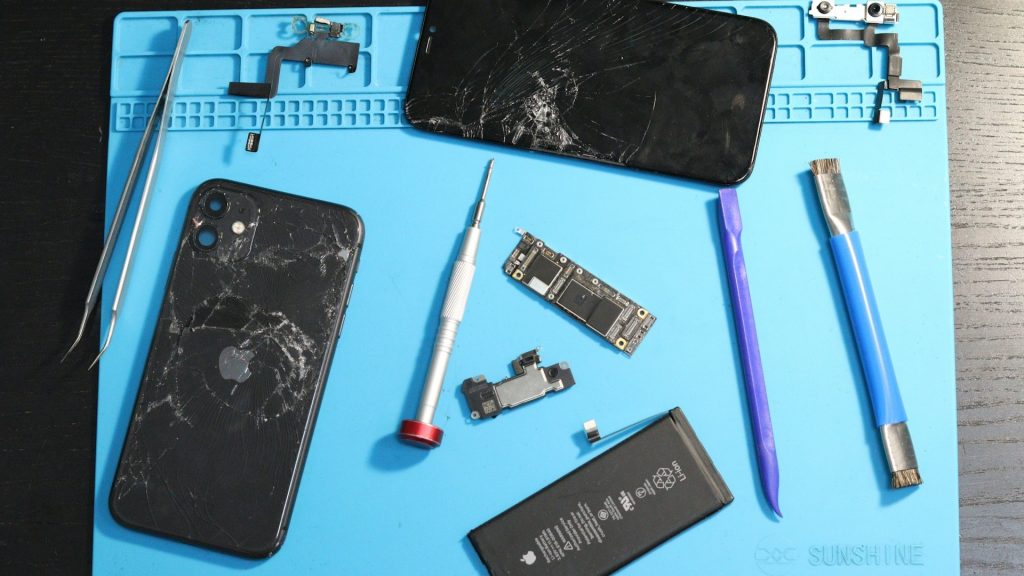 Refurbished smartphones in reparatie met gebarsten schermen en losse onderdelen
