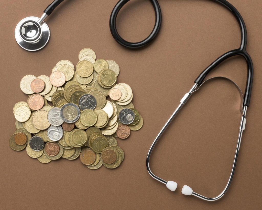 Stethoscoop naast munten als symbool voor zorgkosten en financiële gevolgen van een heupoperatie.